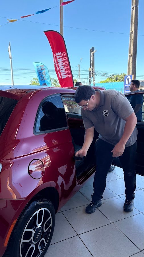 Inspetor abrindo a porta de um carro vermelho